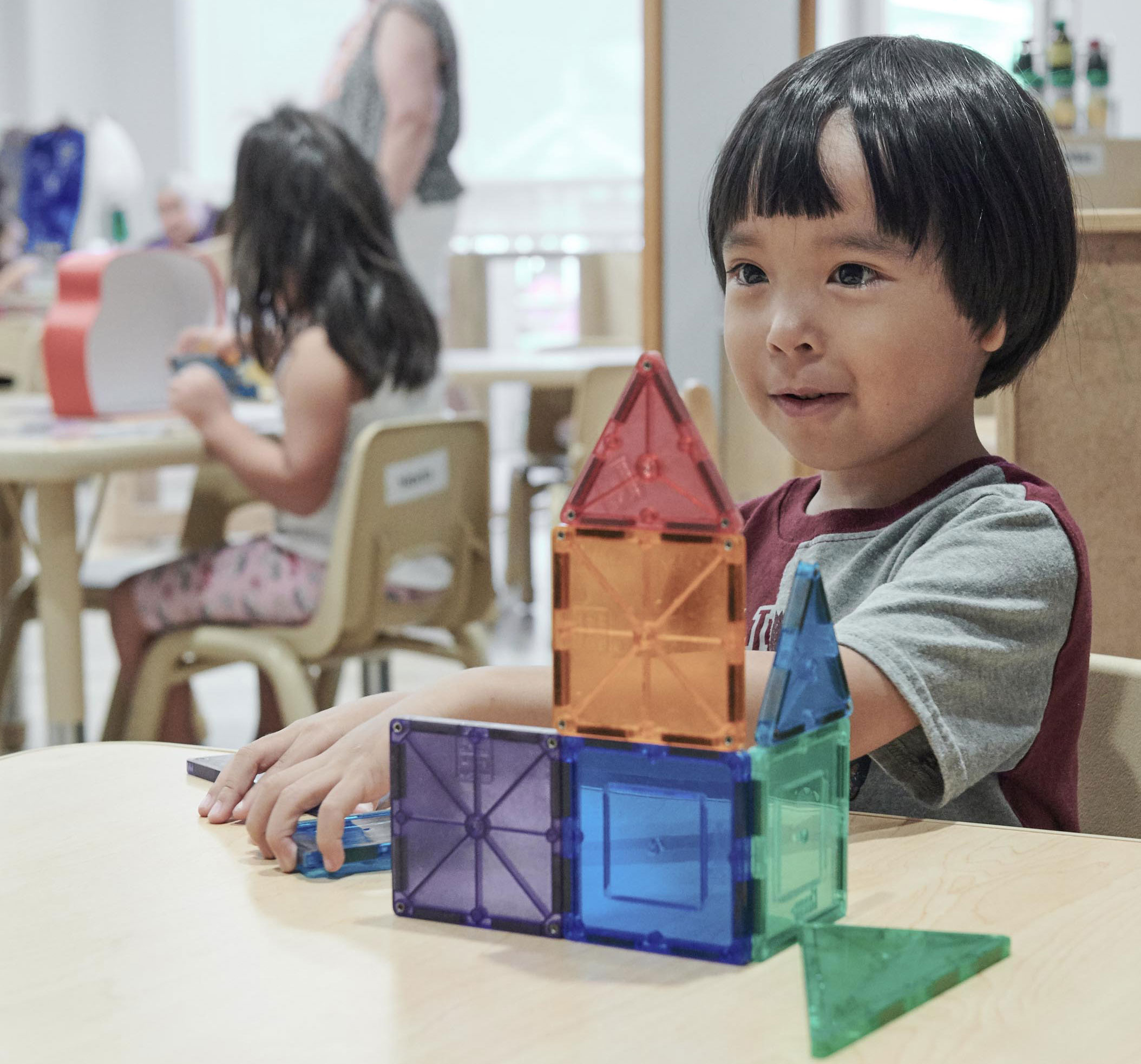 little boy playing with magnet tiles