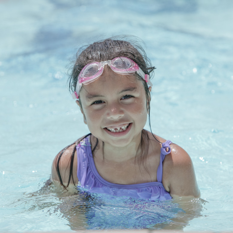 A young girl smiles in the pool