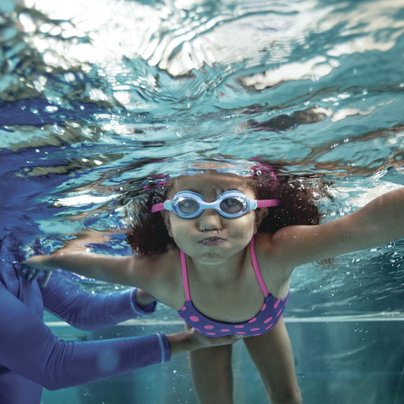 An underwater shot of a young girl taking swimming lessons