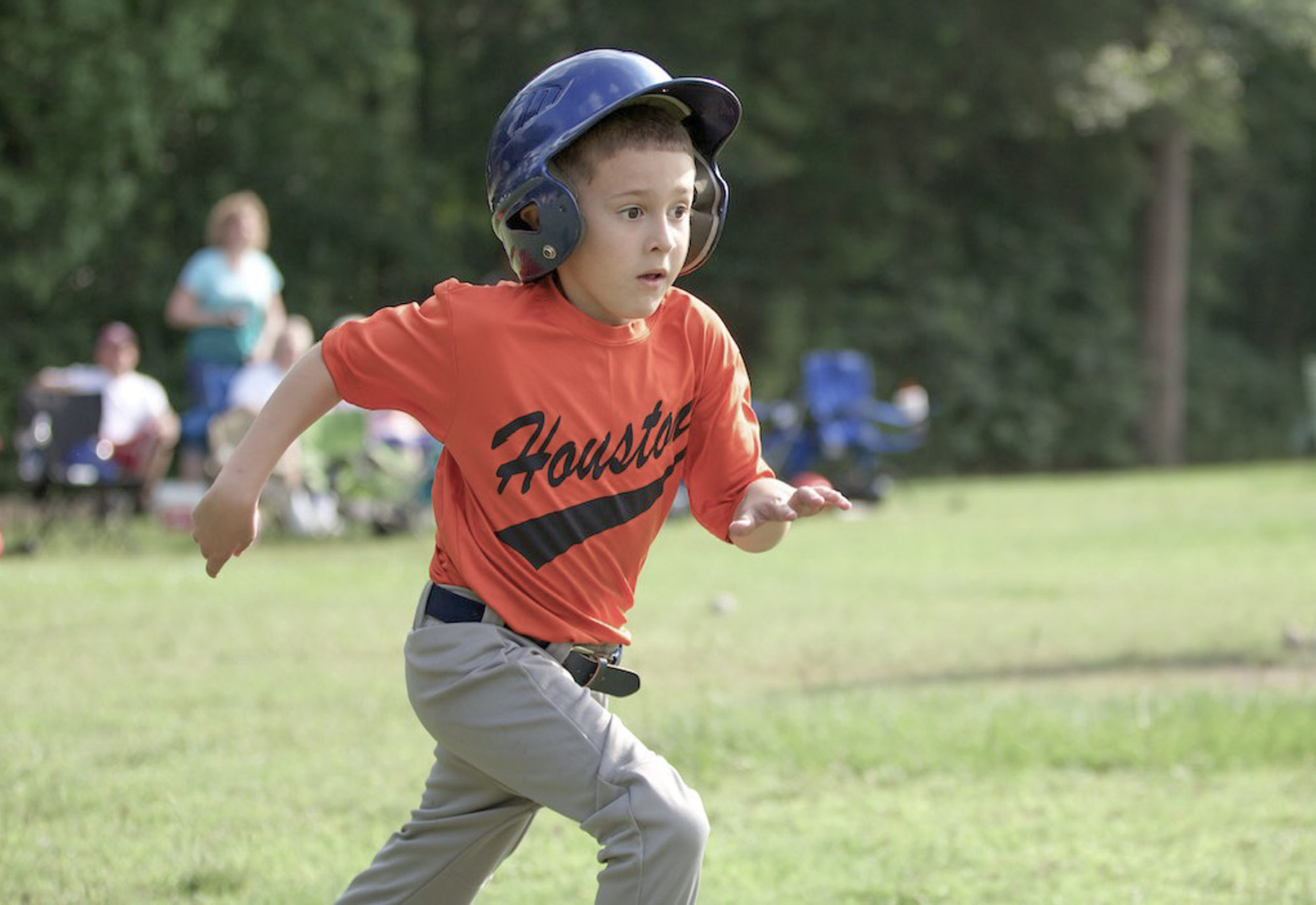 Boy in a baseball uniform running on the field